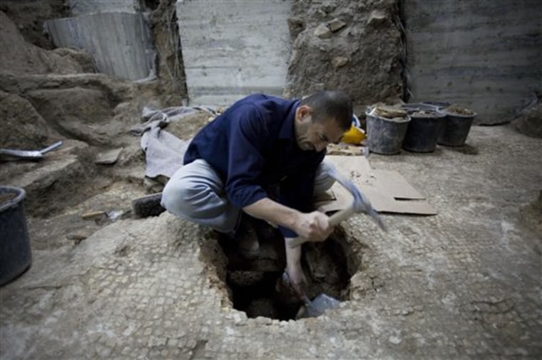 A worker of the Israel Antiquities Authority works at an excavation site in Jerusalem's Old City, Monday, Nov. 22, 2010. Israeli archaeologists preparing the ground for a new Jewish ritual bath in Jerusalem's Old City say they have made a coincidental discovery, an 1,800 year-old-swimming pool built by the same Roman legion that destroyed the ancient city's hallowed second Jewish Temple.
